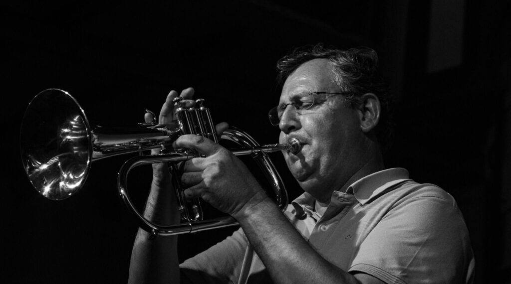 Trompetista tocando la trompeta en directo, en blanco y negro