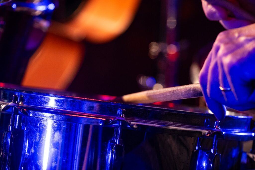 Baterista tocando en directo bajo una luz azul