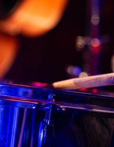 Baterista tocando en directo bajo una luz azul