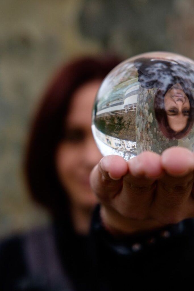 Mano sosteniendo una bola de cristal con un reflejo invertido