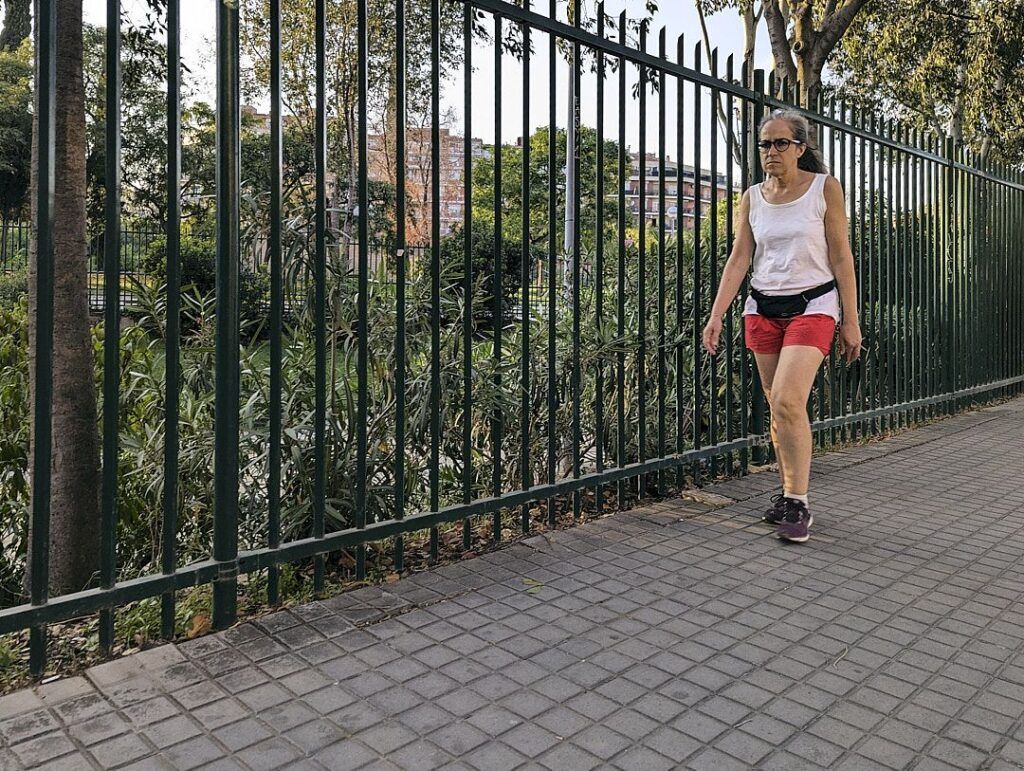 Persona corriendo por un paseo junto a una valla