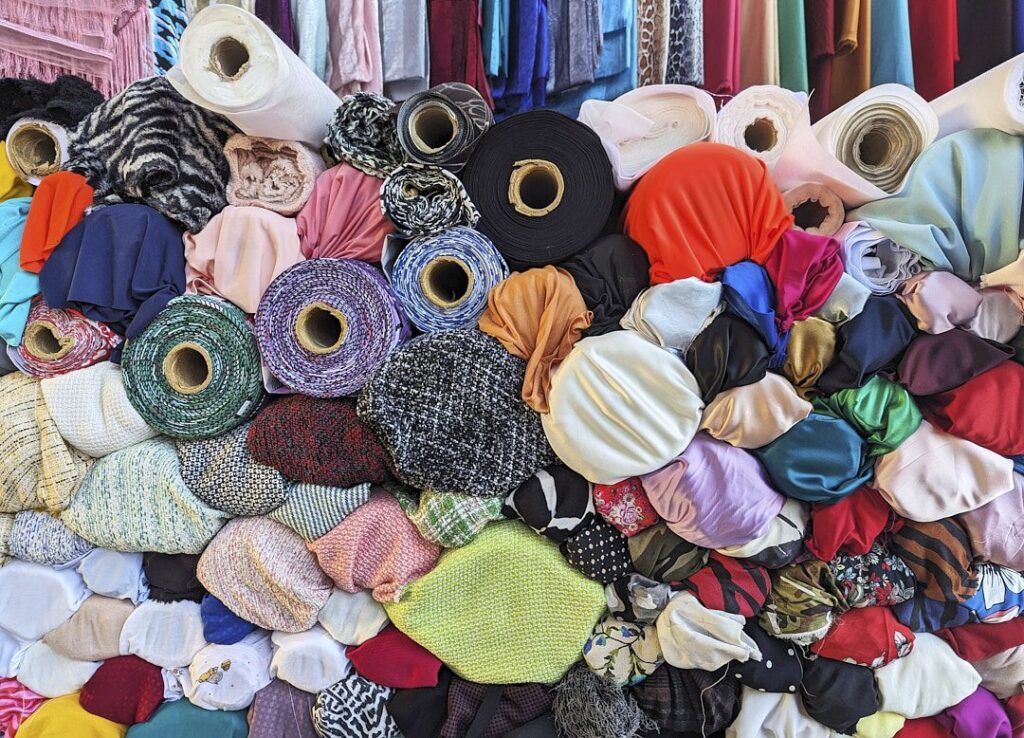 Montón de bobinas de tela de colores en un puesto