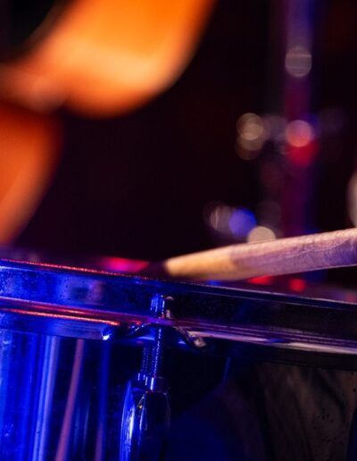 Baterista tocando en directo bajo una luz azul