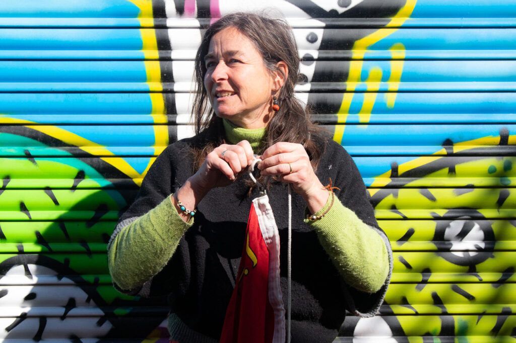Mujer con micrófono actuando ante un mural de grafiti