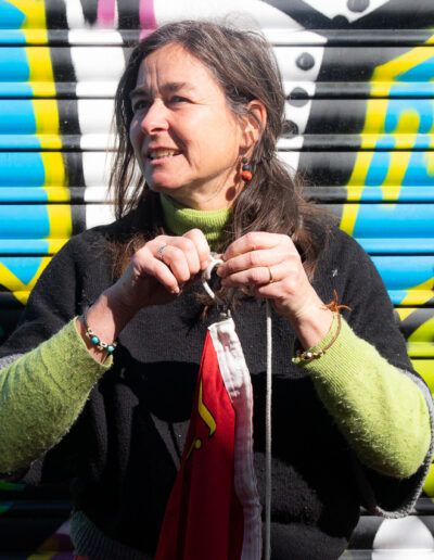 Mujer con micrófono actuando ante un mural de grafiti