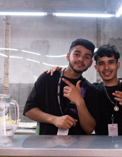 Dos jóvenes posando tras la barra de un local