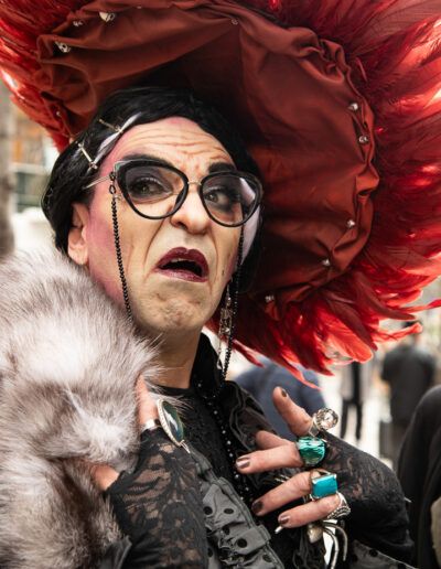 Persona con un elaborado sombrero de plumas rojas y gafas en una fiesta