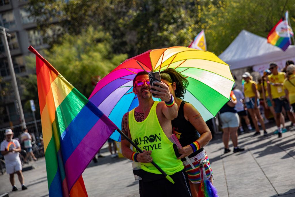Personas con una gran bandera arcoíris en el desfile del Orgullo
