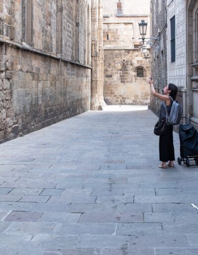 Dos personas con equipaje caminando por un callejón de Barcelona