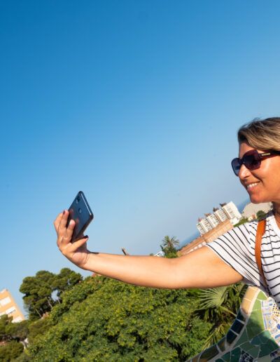 Mujer con gafas de sol tomando un selfi con el móvil al aire libre