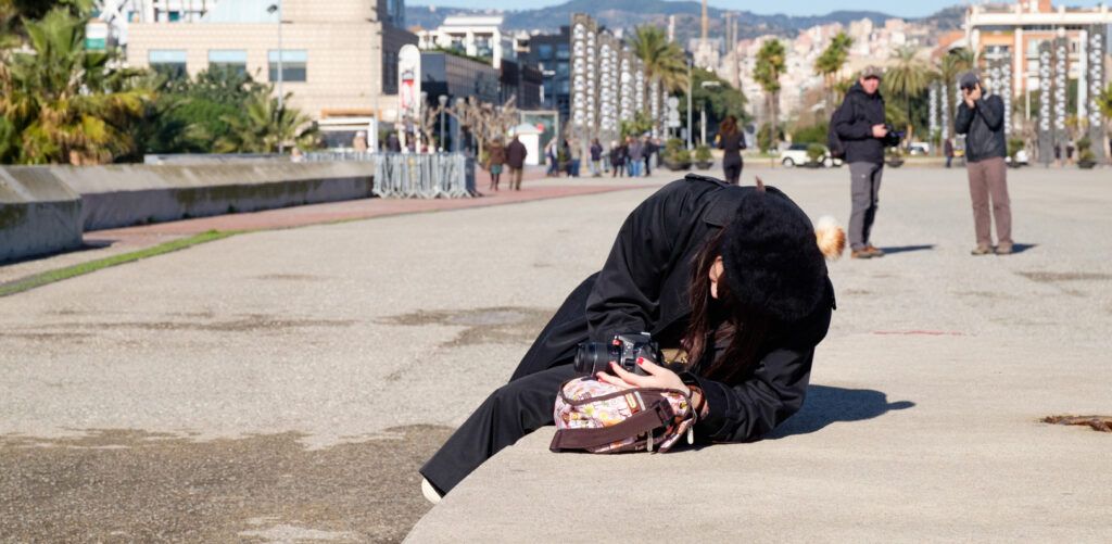 Persona totalmente inclinada fotografiando en un paseo marítimo