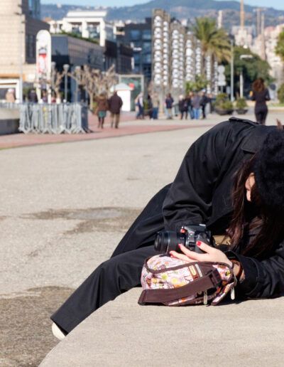 Persona totalmente inclinada fotografiando en un paseo marítimo