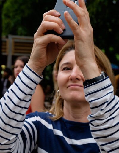 Mujer con jersey de rayas tomando una foto con el teléfono móvil