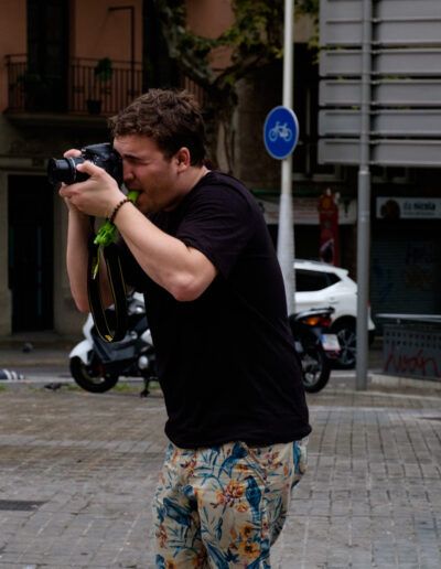 Hombre con pantalón corto fotografiando en una plaza