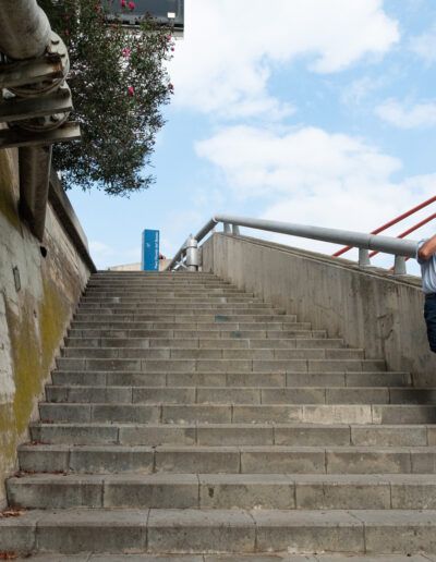 Persona fotografiando en unas escaleras urbanas bajo el cielo azul