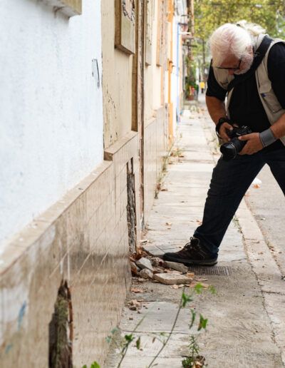 Hombre mayor inclinado fotografiando en una calle de Barcelona