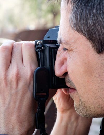 Hombre de perfil fotografiando con su cámara réflex
