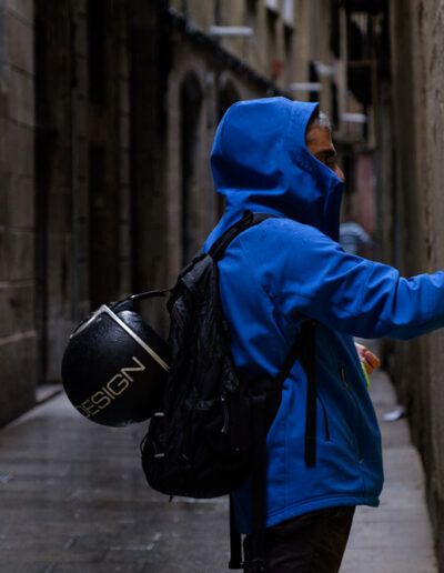 Persona con sudadera azul fotografiando en un callejón estrecho
