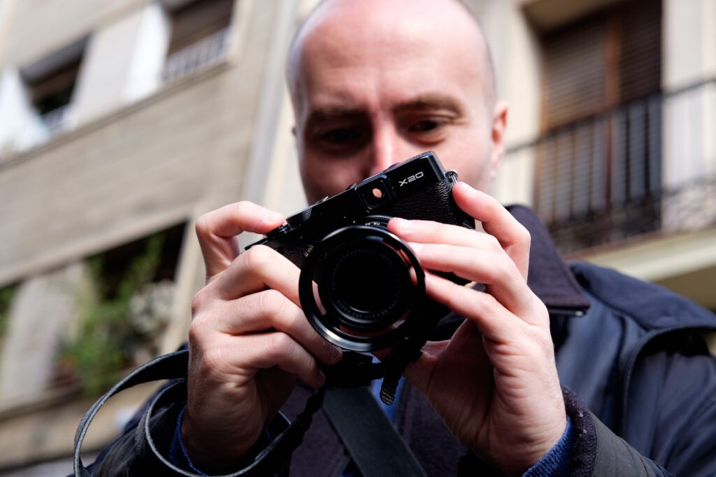 Hombre fotografiando con su cámara en un primer plano en la calle