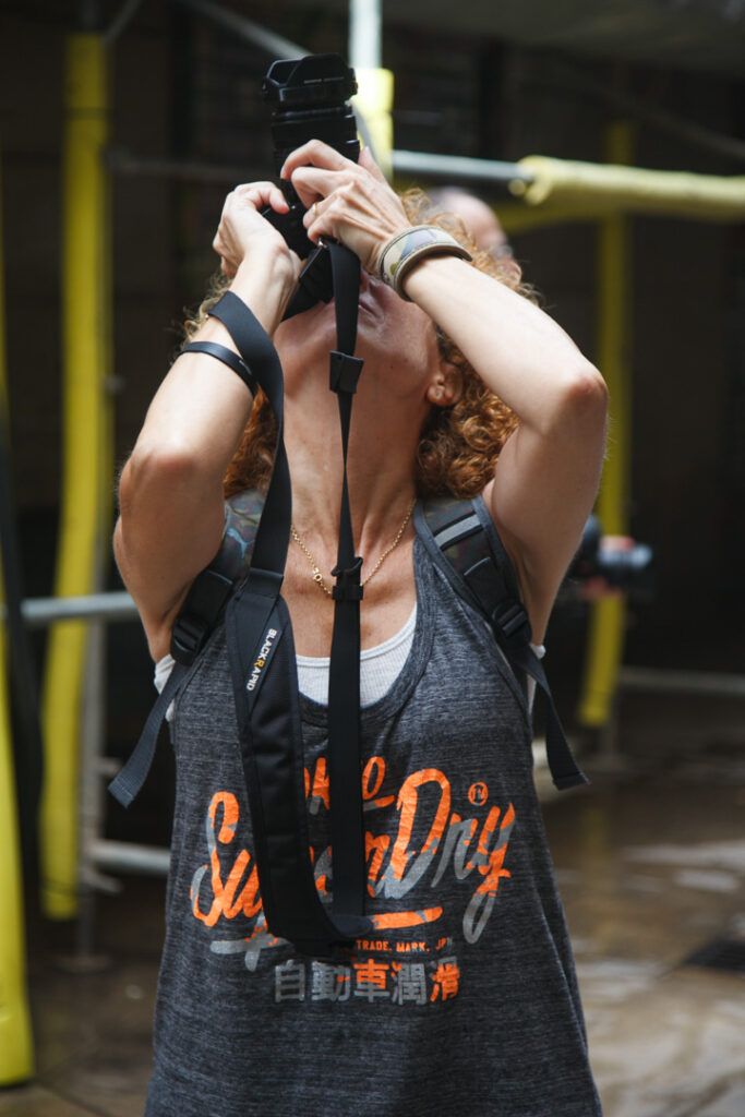 Persona tomando una foto con la cámara en alto en una calle