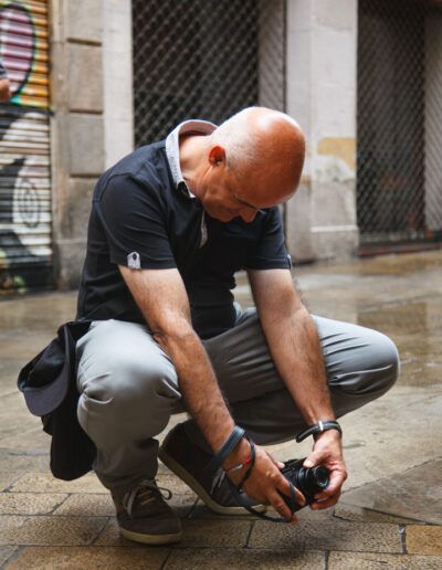 Fotógrafo agachado tomando una foto en una calle de Barcelona