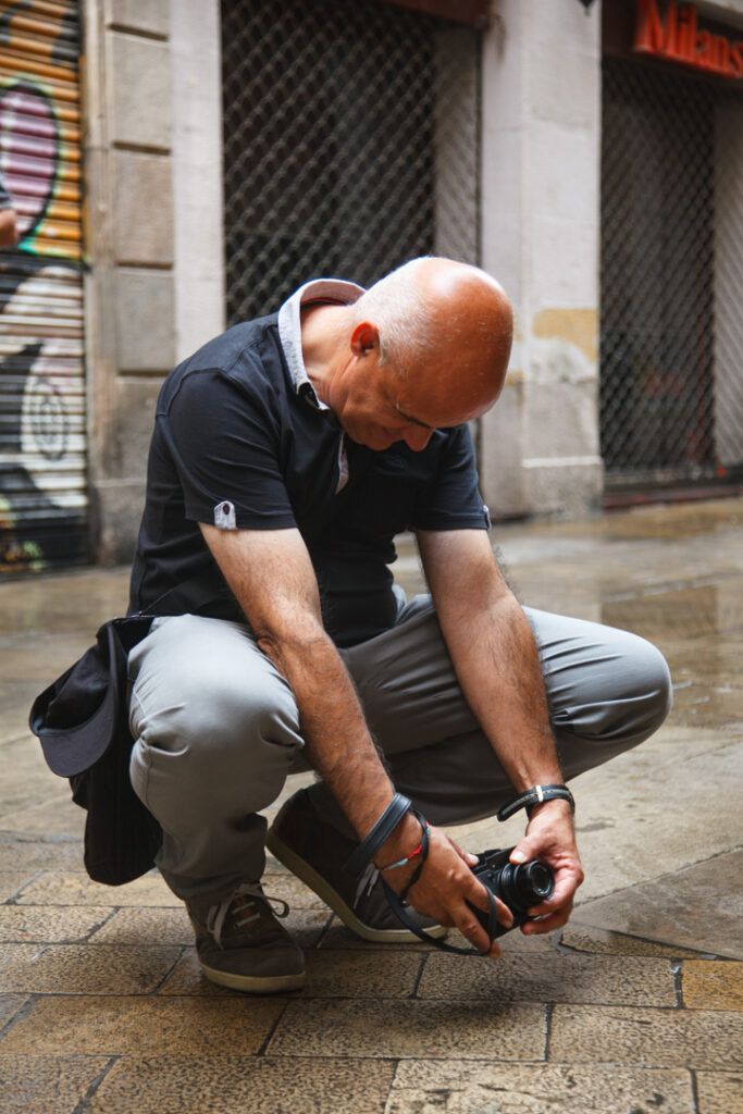 Fotógrafo agachado tomando una foto en una calle de Barcelona