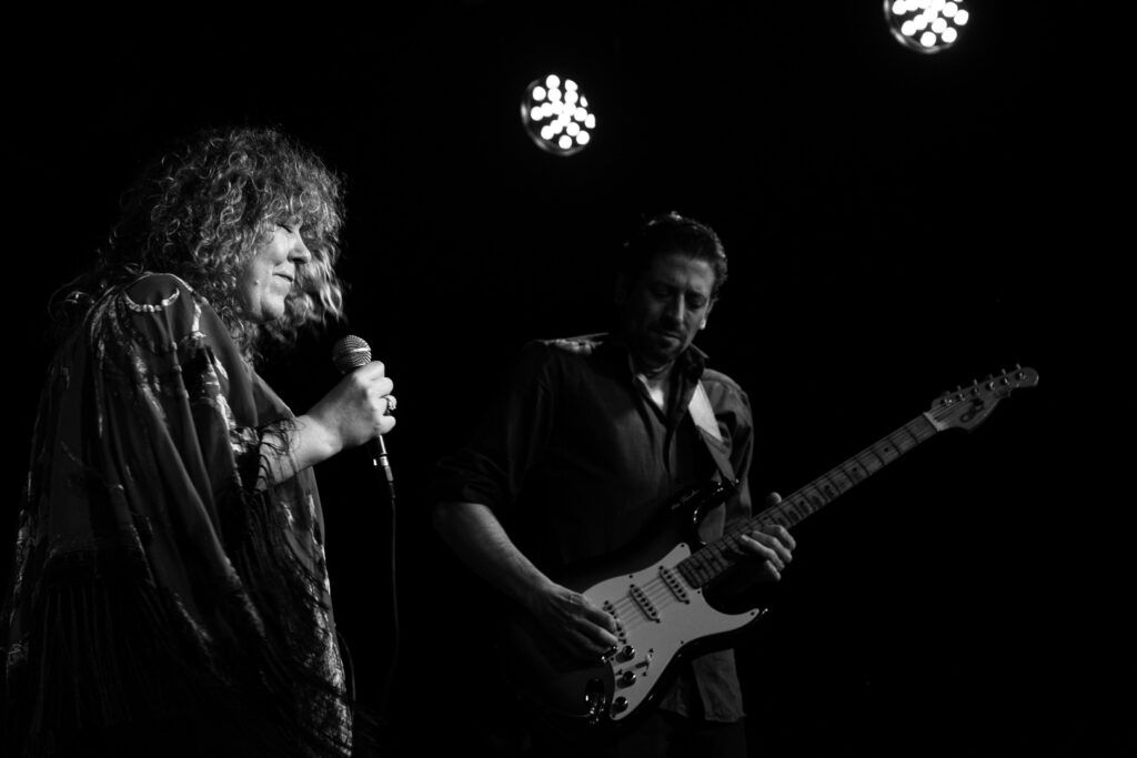 Cantante femenina y guitarrista actuando juntos en el escenario, fotografía en blanco y negro