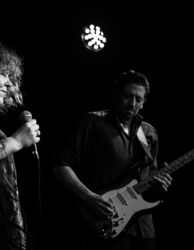 Cantante femenina y guitarrista actuando juntos en el escenario, fotografía en blanco y negro