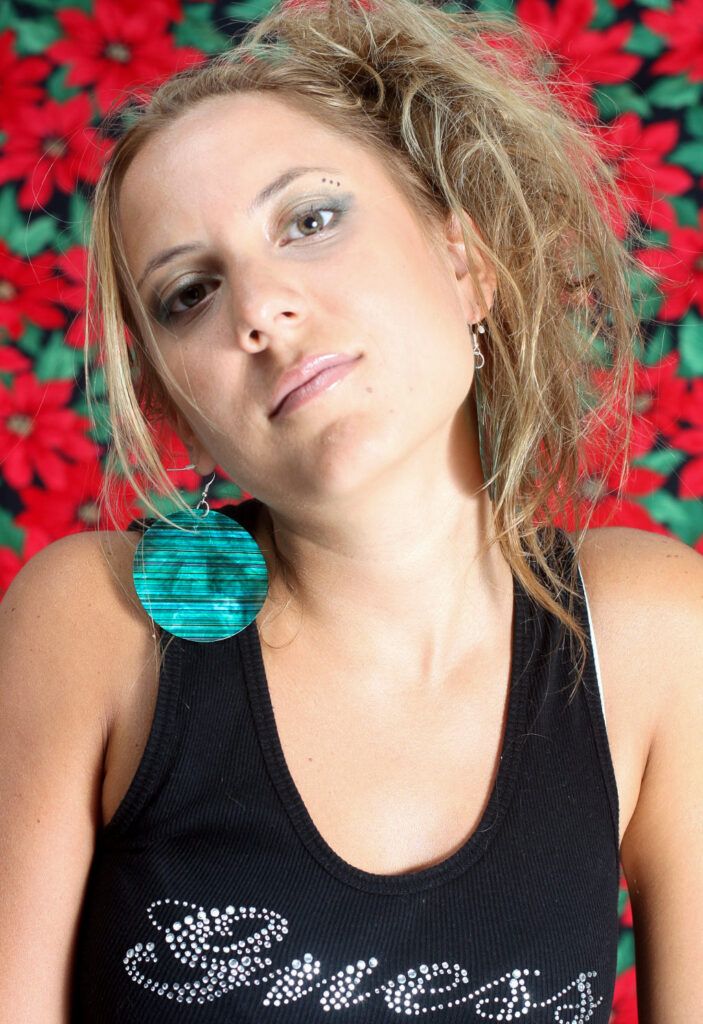 Retrato de una chica joven con trenzas y flores rojas de fondo
