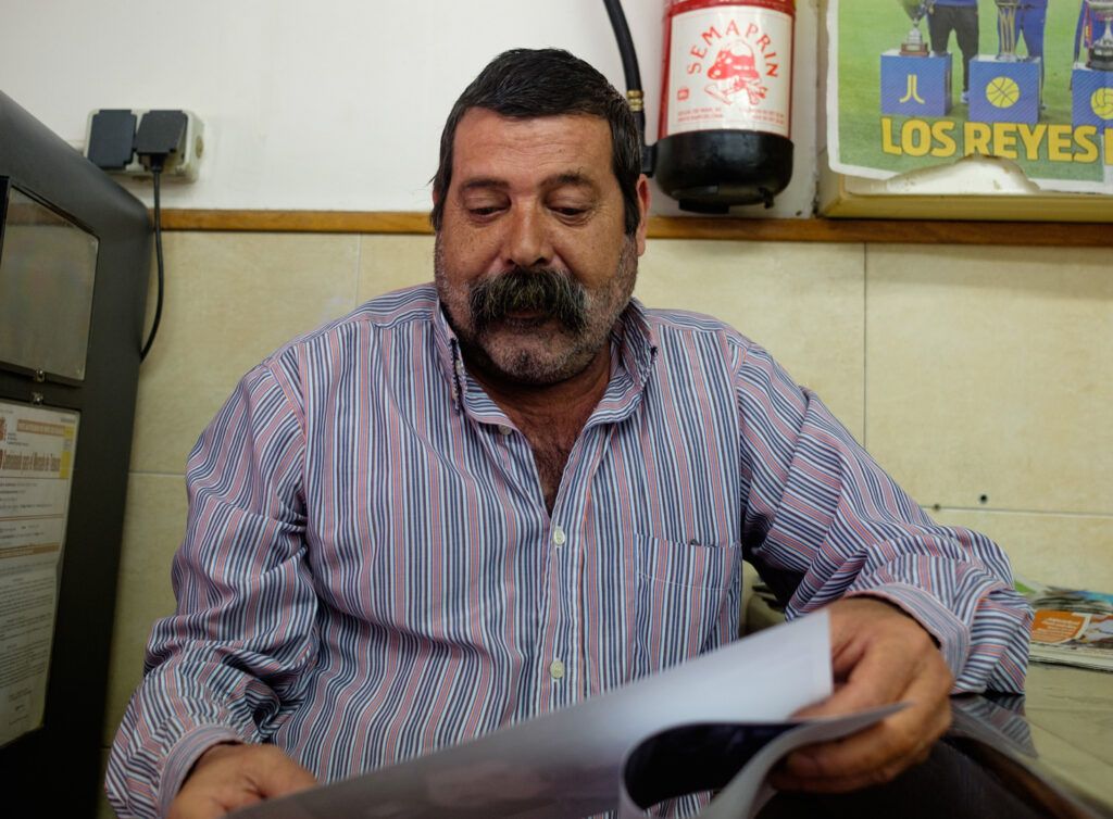 Retrato de un hombre con barba leyendo el diario en un bar