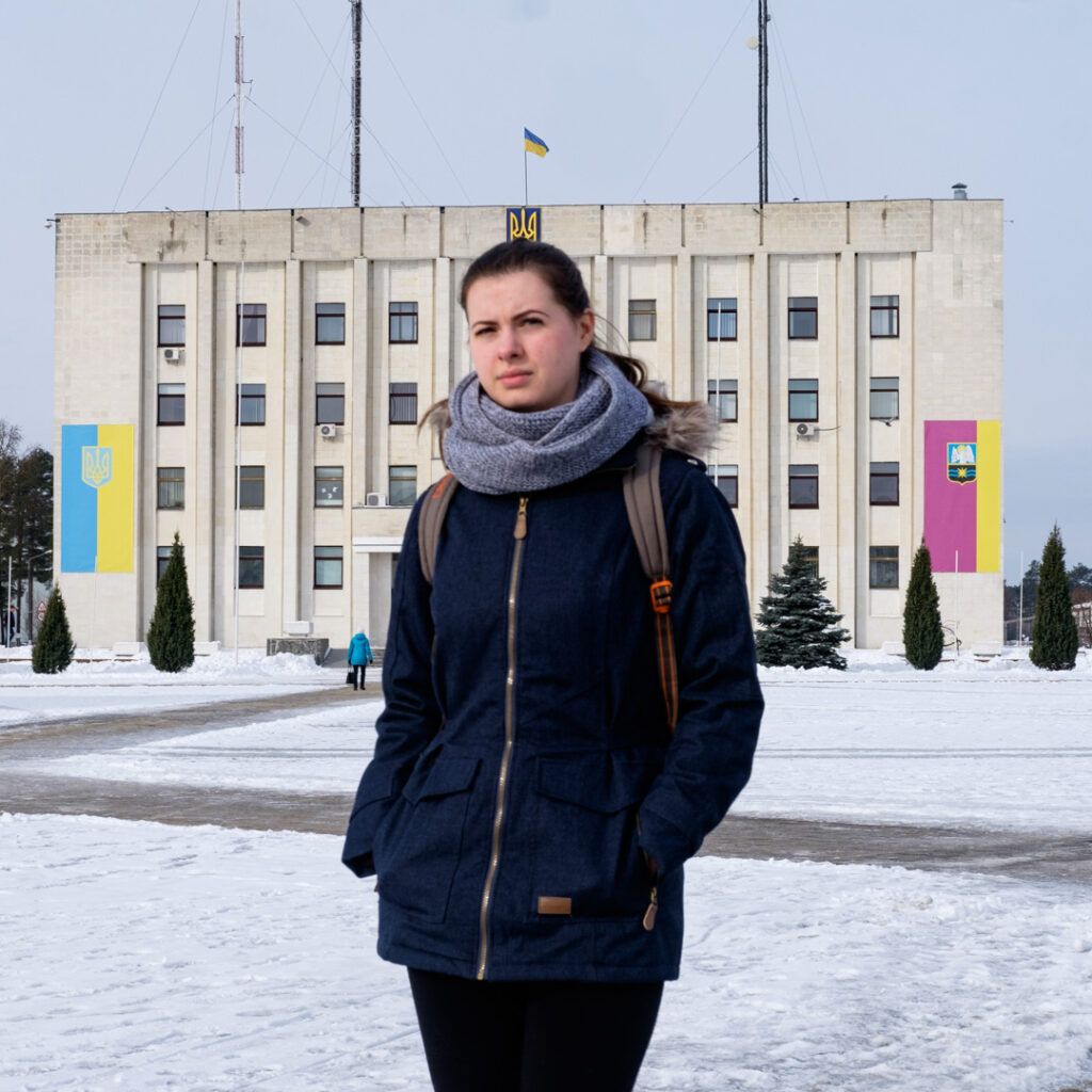Mujer joven con bufanda ante un edificio en Kiev