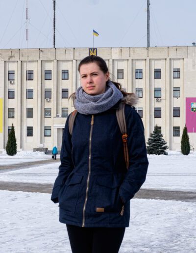 Mujer joven con bufanda ante un edificio en Kiev