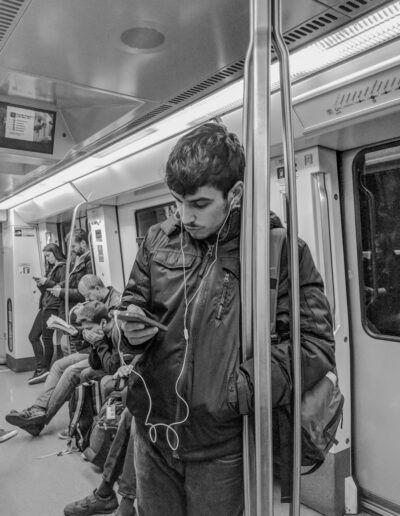 Persona escuchando música con auriculares en el metro, fotografía callejera de Lluís Ridao