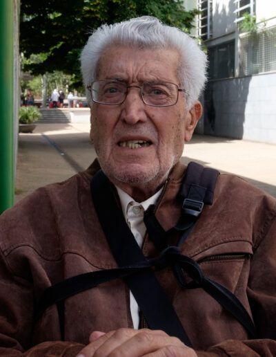 Hombre mayor de barba blanca con chaleco, retrato de calle