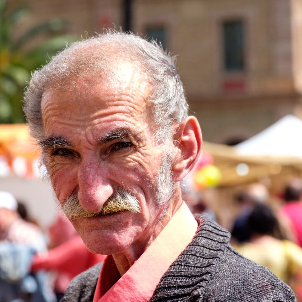 Retrato de un hombre mayor de barba blanca en un mercado de Barcelona