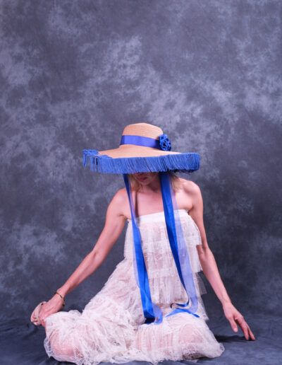 Mujer posando con vestido azul en un retrato artístico de estudio sobre fondo oscuro