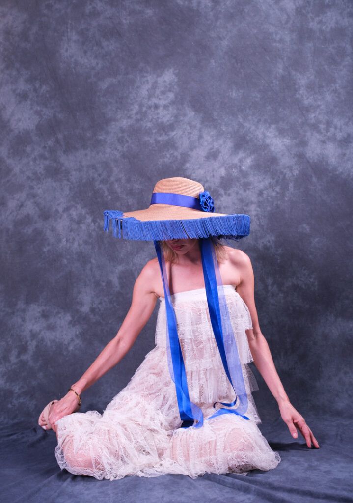 Mujer posando con vestido azul en un retrato artístico de estudio sobre fondo oscuro