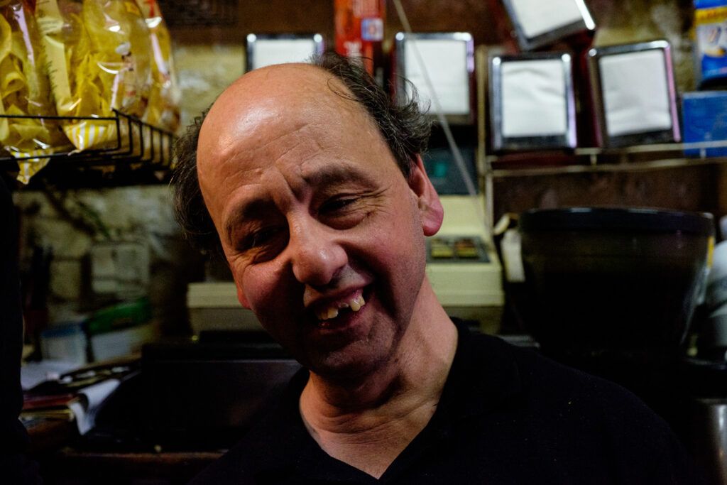 Hombre sonriente en un bar, retrato de calle