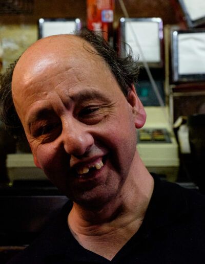 Hombre sonriente en un bar, retrato de calle