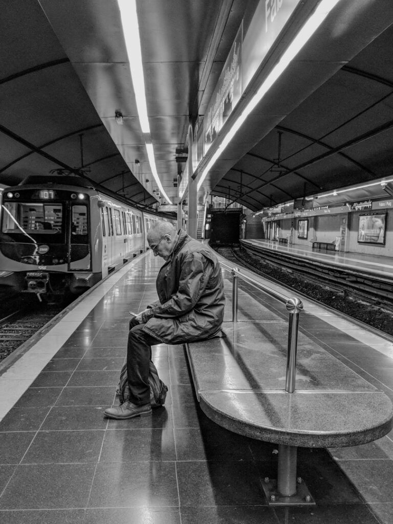 Hombre solitario esperando el metro en blanco y negro, fotografía callejera de Lluís Ridao en Barcelona