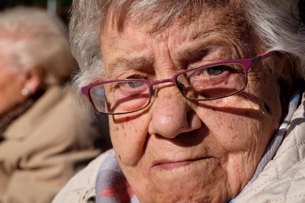Primer plano de una mujer mayor con gafas, retrato de calle