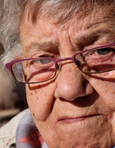 Primer plano de una mujer mayor con gafas, retrato de calle