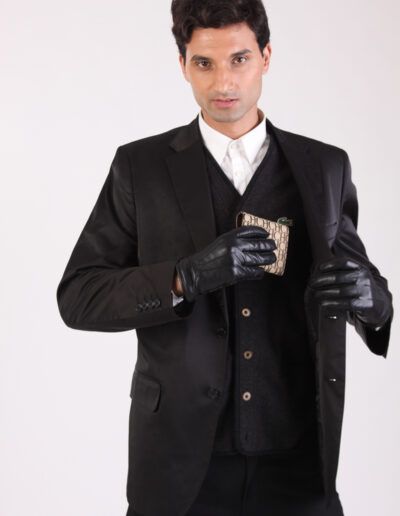 Retrato de estudio de un hombre con traje oscuro sosteniendo una cartera, fondo claro