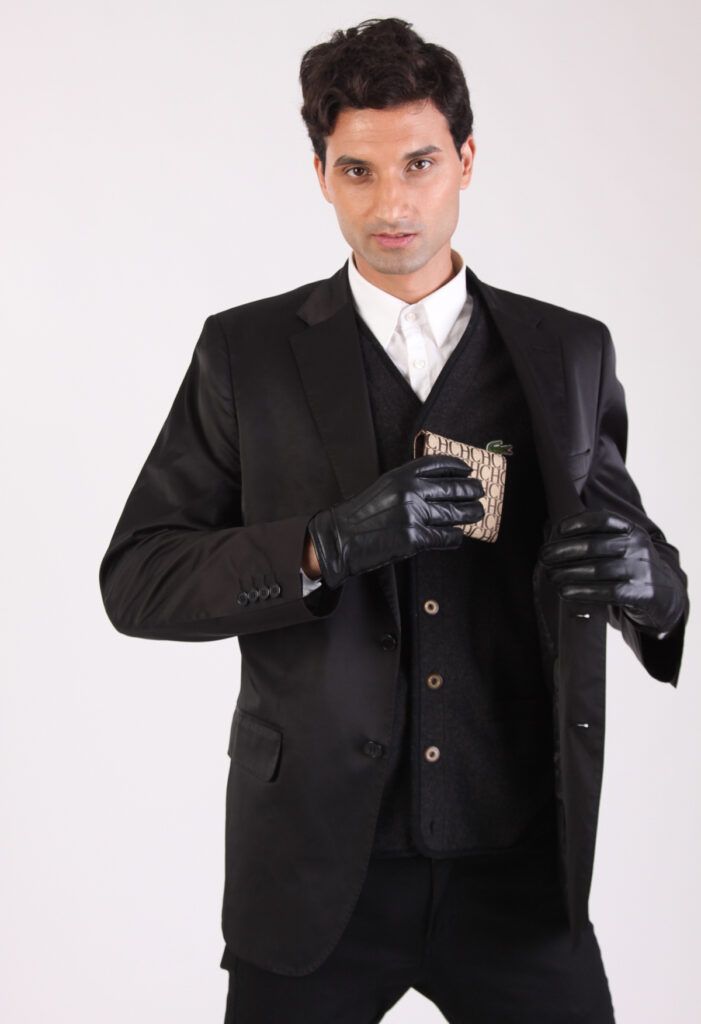 Retrato de estudio de un hombre con traje oscuro sosteniendo una cartera, fondo claro