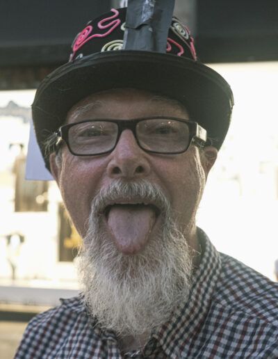 Hombre mayor de barba blanca sacando la lengua en un gesto pícaro, Barcelona