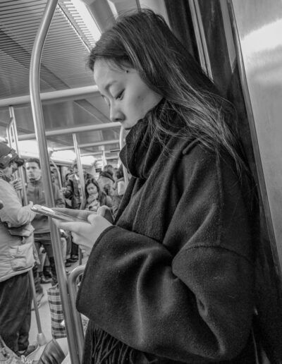 Persona mirando likes en redes sociales en el metro, fotografía callejera de Lluís Ridao