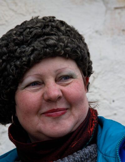 Mujer de cabello corto y rizado sonriendo en la calle