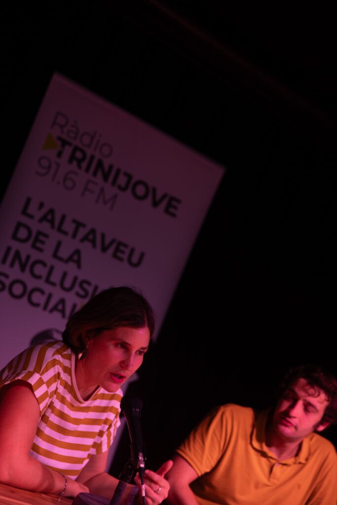 Dos locutores jóvenes ante el micrófono con el cartel de Ràdio Trinijove 91.6 FM