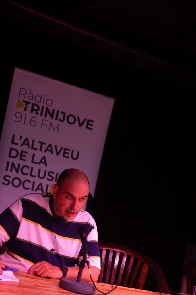 Hombre con jersey de rayas ante el micrófono junto al cartel de Ràdio Trinijove