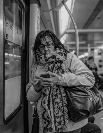 Persona respondiendo correos electrónicos en el teléfono en el metro, fotografía callejera de Lluís Ridao
